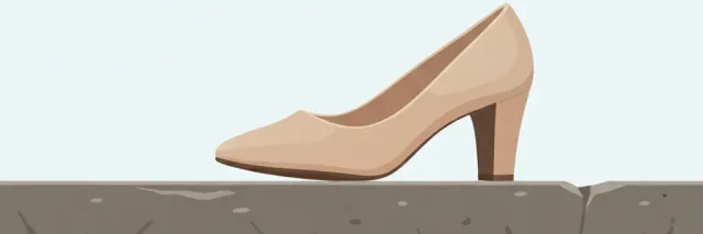 A single high-heeled shoe lying on its side on a flat stone step, viewed from a low angle, calm muted palette.
